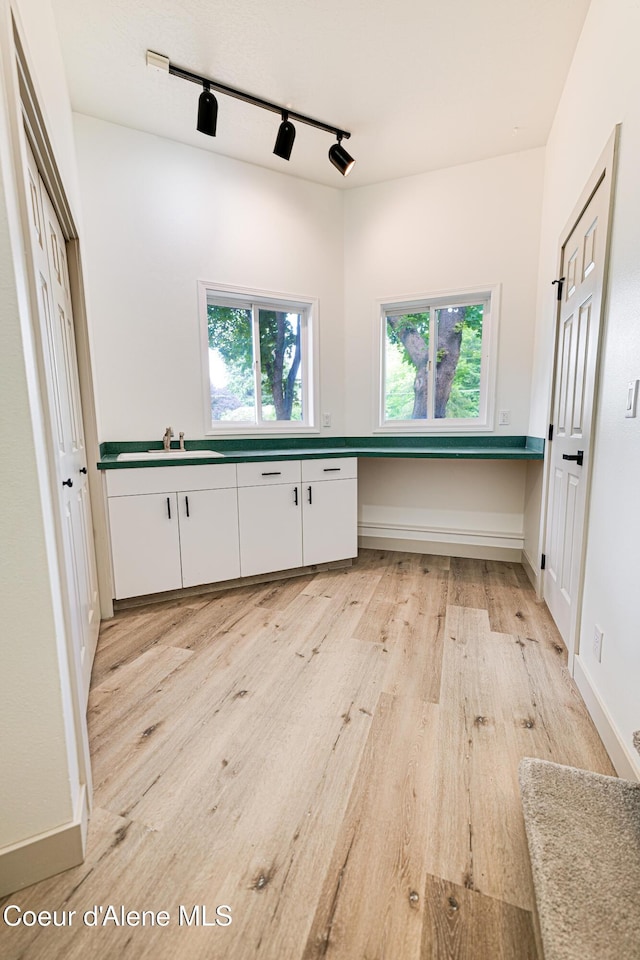 3809 N Moccasin Rd, Coeur Dalene, ID 83815 - kitchen featuring a sink, track lighting, light wood finished floors, white cabinetry, and dark countertops