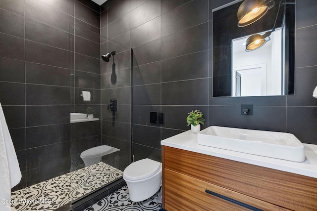 175 N Holidays Hills Dr, Liberty Lake, WA 99019 - bathroom with tile walls, toilet, tiled shower, vanity, and tile patterned floors