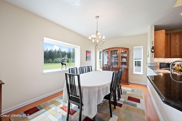 30587 S Sunray Trl, Worley, ID 83876 - dining space with a chandelier, baseboards, and light wood-style floors