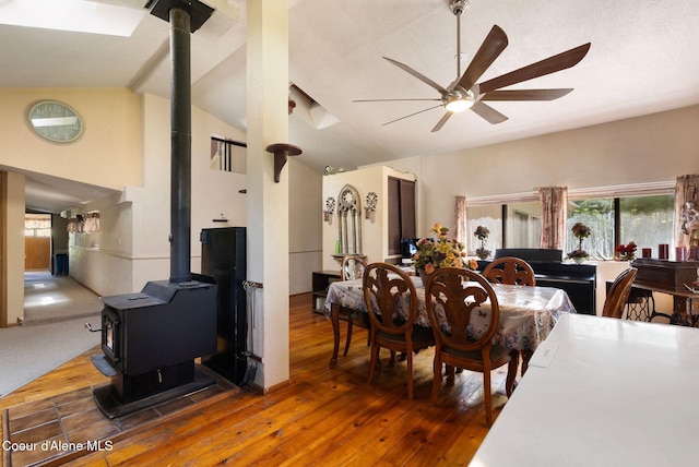 910 Otts Rd, Sagle, ID 83860 - dining room with a wood stove, ceiling fan, wood-type flooring, healthy amount of natural light, and high vaulted ceiling
