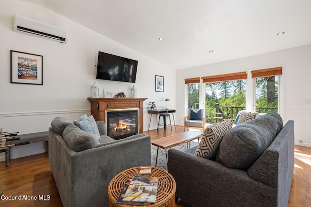 9298 N Clarkview Pl, Hayden, ID 83835 - living area featuring a wall unit AC, lofted ceiling, wood finished floors, a glass covered fireplace, and recessed lighting