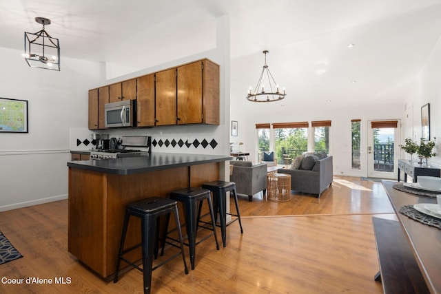 9298 N Clarkview Pl, Hayden, ID 83835 - kitchen with stainless steel microwave, stove, a chandelier, dark countertops, and brown cabinets
