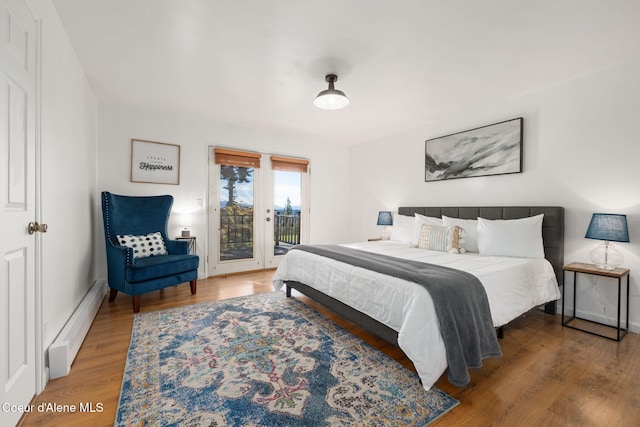 9298 N Clarkview Pl, Hayden, ID 83835 - bedroom with baseboard heating, access to exterior, wood finished floors, and baseboards