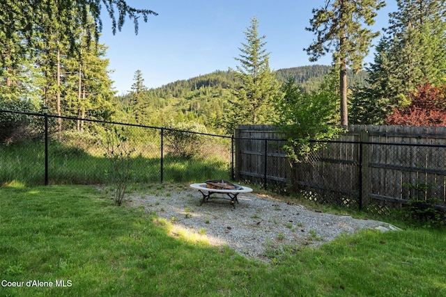 9298 N Clarkview Pl, Hayden, ID 83835 - view of yard featuring a fire pit and a wooded view