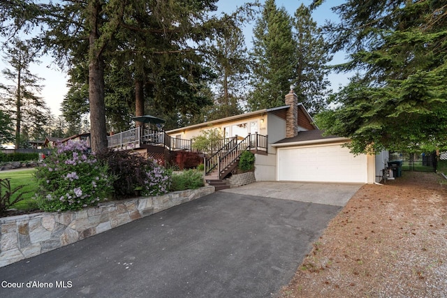 9298 N Clarkview Pl, Hayden, ID 83835 - view of front of home with stairway, asphalt driveway, a garage, and a chimney