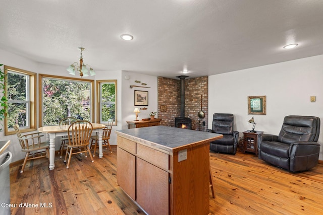 723 Trout Crk Rd, Sandpoint, ID 83864 - kitchen featuring open floor plan, a wood stove, a kitchen island, light wood finished floors, and recessed lighting