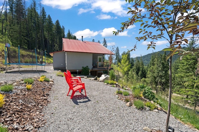723 Trout Crk Rd, Sandpoint, ID 83864 - view of yard featuring a trampoline and a wooded view