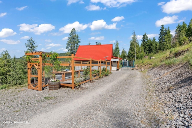 723 Trout Crk Rd, Sandpoint, ID 83864 - view of front of house featuring a vegetable garden, a metal roof, and an outbuilding