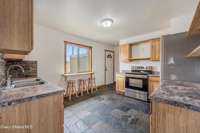 2016 N 7th St, Coeur Dalene, ID 83814 - kitchen with appliances with stainless steel finishes, a sink, stone tile floors, light brown cabinetry, and baseboards