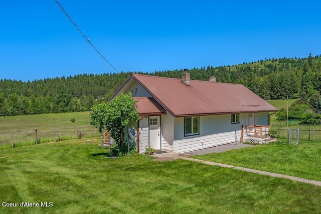 25024 N Derting Rd, Hayden, ID 83835 - view of front of home featuring a forest view, a chimney, and metal roof