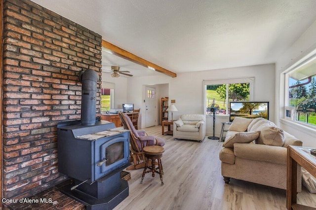 25024 N Derting Rd, Hayden, ID 83835 - living room with a wood stove, light wood-type flooring, beam ceiling, and ceiling fan