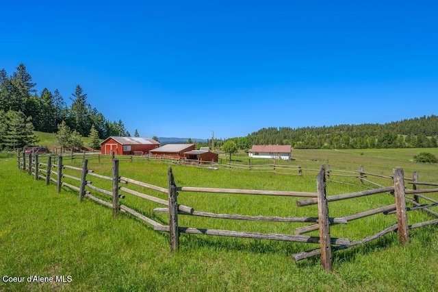 25024 N Derting Rd, Hayden, ID 83835 - view of yard featuring an outdoor structure, a view of rural / pastoral area, a wooded view, and a pole building