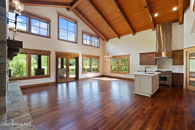 409 N Idaho Club Dr, Sandpoint, ID 83864 - kitchen with high end range, ventilation hood, open floor plan, a chandelier, and wooden ceiling with exposed beams
