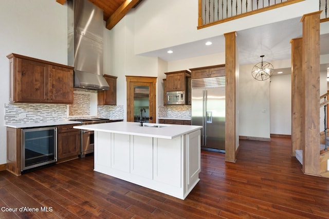 409 N Idaho Club Dr, Sandpoint, ID 83864 - kitchen featuring built in appliances, wine cooler, wall chimney range hood, a sink, and dark wood-style floors