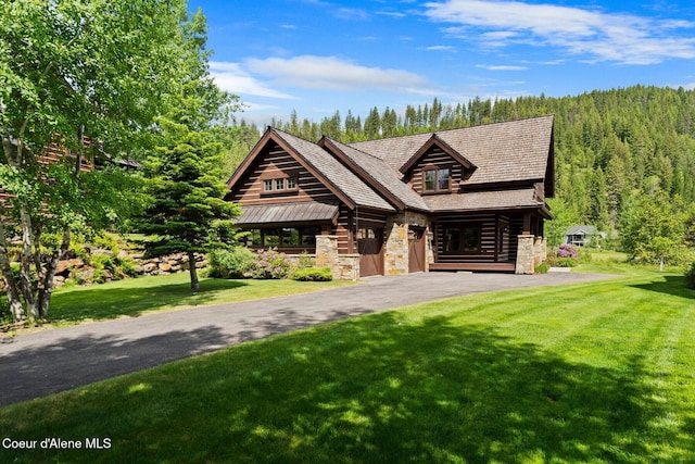409 N Idaho Club Dr, Sandpoint, ID 83864 - log home featuring stone siding, a front yard, a view of trees, and driveway