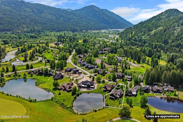 409 N Idaho Club Dr, Sandpoint, ID 83864 - aerial view of residential area featuring property boundaries highlighted, a heavily wooded area, and a water and mountain view