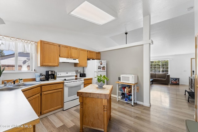 3149 N 12th St, Coeur Dalene, ID 83814 - kitchen featuring under cabinet range hood, white appliances, vaulted ceiling, light wood-style flooring, and a sink