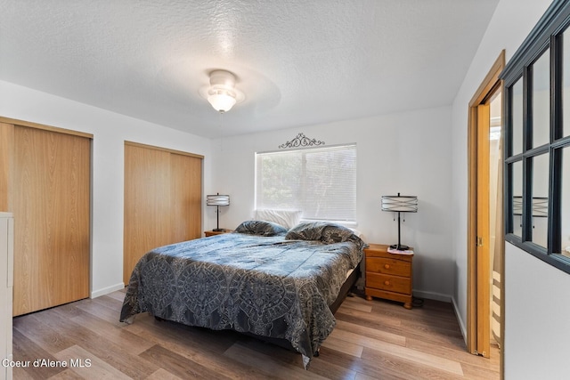 3149 N 12th St, Coeur Dalene, ID 83814 - bedroom featuring wood finished floors, two closets, a textured ceiling, and baseboards