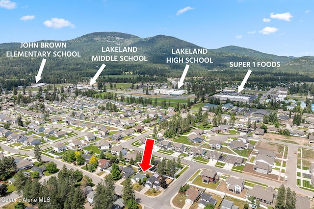 6687 W Flagstaff St, Rathdrum, ID 83858 - aerial view of property and surrounding area featuring a mountain backdrop and nearby suburban area