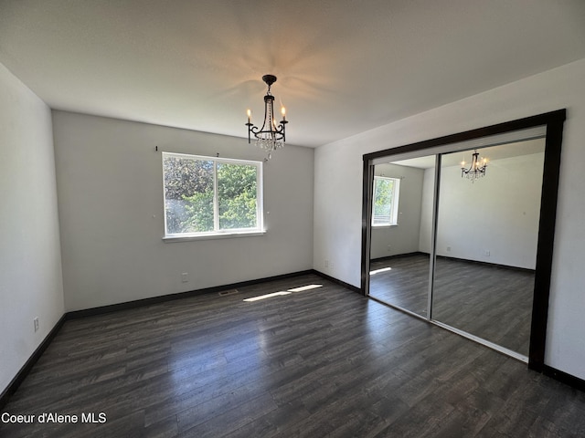8309 N Vantage Dr, Hayden, ID 83835 - unfurnished bedroom with a chandelier, multiple windows, and wood finished floors