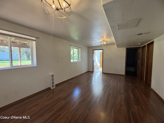 8309 N Vantage Dr, Hayden, ID 83835 - spare room with dark wood-type flooring, a textured ceiling, a chandelier, and baseboards
