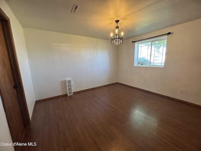 8309 N Vantage Dr, Hayden, ID 83835 - empty room with dark wood-style floors, a chandelier, baseboards, and a textured ceiling