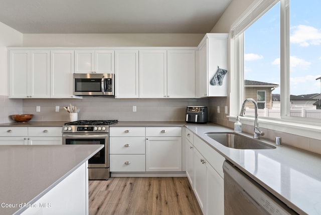 3062 N Coco St, Post Falls, ID 83854 - kitchen with stainless steel appliances, a sink, healthy amount of natural light, and white cabinetry