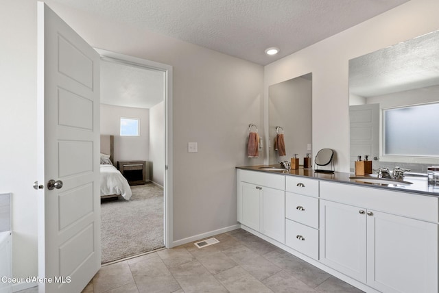 3062 N Coco St, Post Falls, ID 83854 - ensuite bathroom featuring a textured ceiling, double vanity, and baseboards