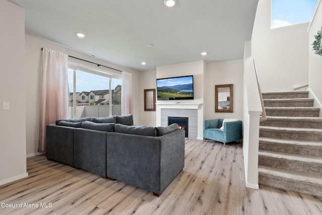 3062 N Coco St, Post Falls, ID 83854 - living area featuring light wood-style floors, stairs, a tile fireplace, recessed lighting, and baseboards