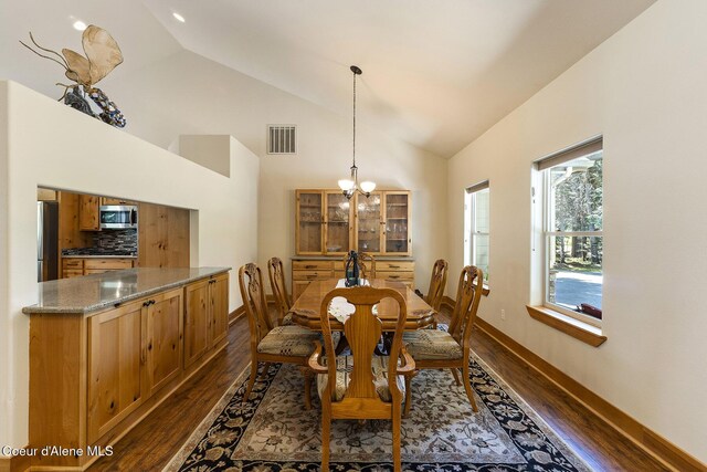 25400 N Lantern Hill Rd, Rathdrum, ID 83858 - dining area featuring dark wood finished floors, vaulted ceiling, and a chandelier
