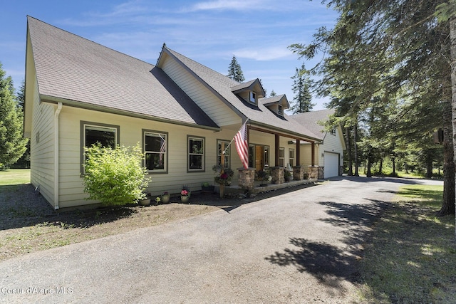 25400 N Lantern Hill Rd, Rathdrum, ID 83858 - view of front facade with a porch, roof with shingles, asphalt driveway, and an attached garage
