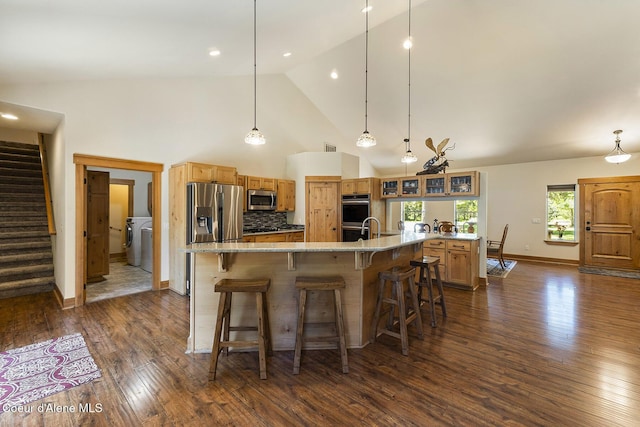 25400 N Lantern Hill Rd, Rathdrum, ID 83858 - kitchen featuring stainless steel appliances, high vaulted ceiling, a spacious island, dark wood-type flooring, and washer / clothes dryer