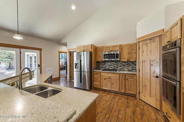 25400 N Lantern Hill Rd, Rathdrum, ID 83858 - kitchen with appliances with stainless steel finishes, dark wood-style floors, tasteful backsplash, high vaulted ceiling, and hanging light fixtures