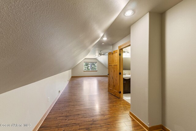 25400 N Lantern Hill Rd, Rathdrum, ID 83858 - additional living space with hardwood / wood-style flooring, a textured ceiling, lofted ceiling, and recessed lighting