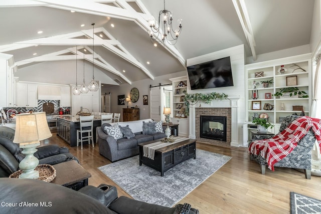 10383 N Morris Rd, Hayden Lake, ID 83835 - living area featuring a chandelier, a barn door, beam ceiling, light wood-style flooring, and a fireplace