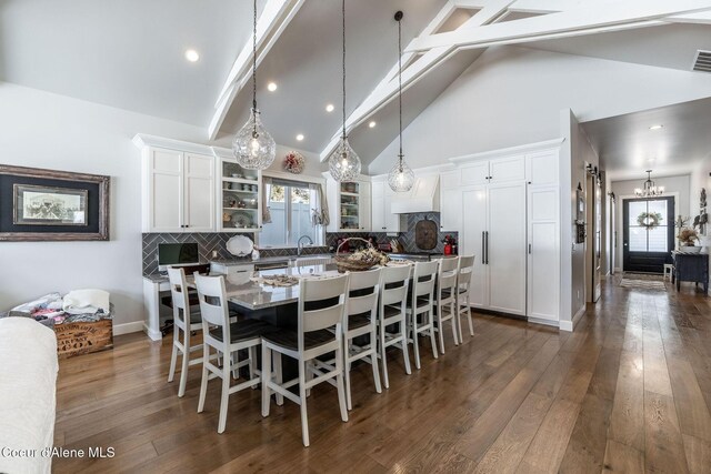 10383 N Morris Rd, Hayden Lake, ID 83835 - dining room featuring a chandelier, beamed ceiling, dark wood-style floors, high vaulted ceiling, and healthy amount of natural light