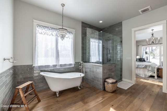 10383 N Morris Rd, Hayden Lake, ID 83835 - full bathroom with a chandelier, a stall shower, tile walls, a freestanding tub, and ensuite bathroom