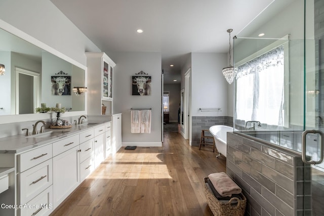 10383 N Morris Rd, Hayden Lake, ID 83835 - bathroom featuring double vanity, a freestanding tub, wood finished floors, a shower stall, and a chandelier