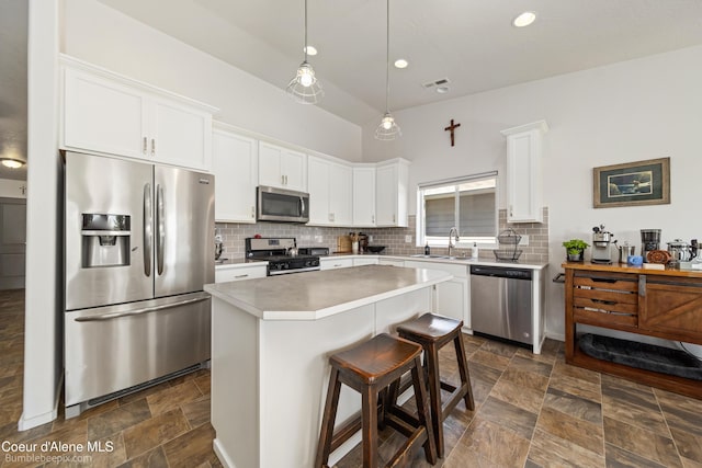 4281 N Shelburne Loop, Post Falls, ID 83854 - kitchen with stainless steel appliances, white cabinetry, a center island, stone finish flooring, and recessed lighting
