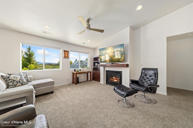 4281 N Shelburne Loop, Post Falls, ID 83854 - carpeted living room with ceiling fan, a glass covered fireplace, baseboards, lofted ceiling, and recessed lighting