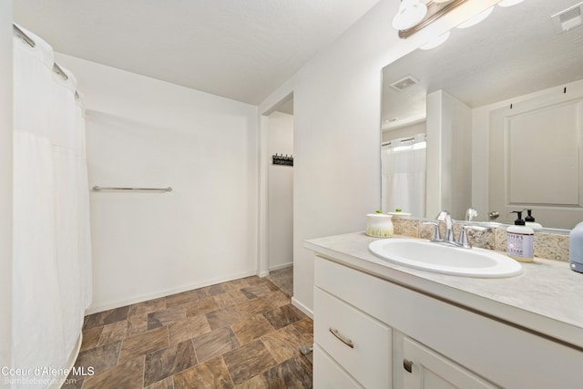4281 N Shelburne Loop, Post Falls, ID 83854 - full bath featuring vanity, stone finish floors, baseboards, and a shower with curtain