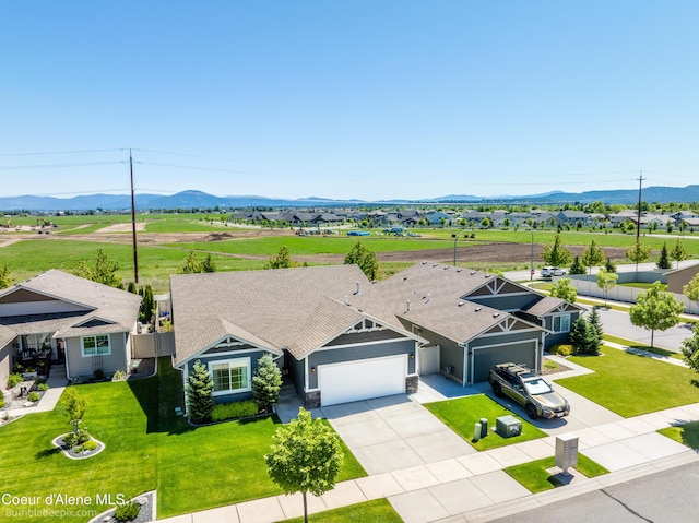 4281 N Shelburne Loop, Post Falls, ID 83854 - view of front of home with an attached garage, a mountain view, driveway, and a front yard