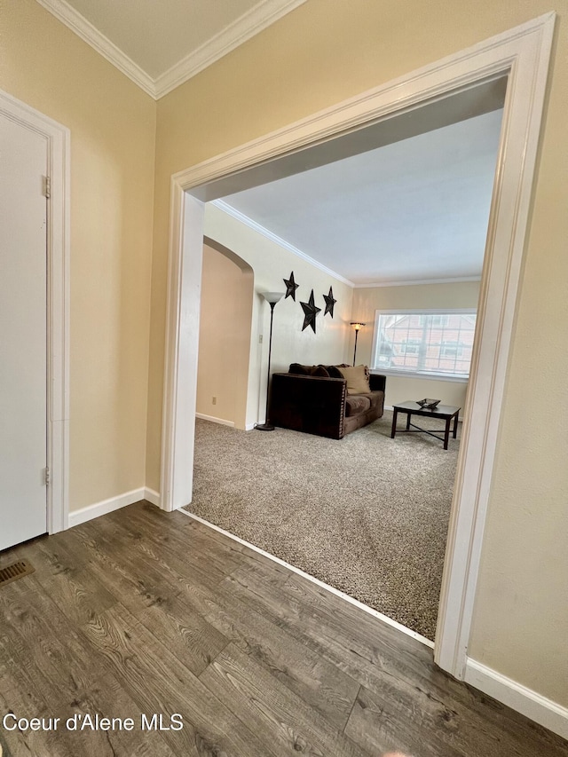 124 King St, Wallace, ID 83873 - living area featuring crown molding, arched walkways, dark wood finished floors, and baseboards