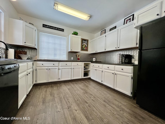 124 King St, Wallace, ID 83873 - kitchen with black appliances, white cabinetry, dark wood finished floors, dark countertops, and backsplash