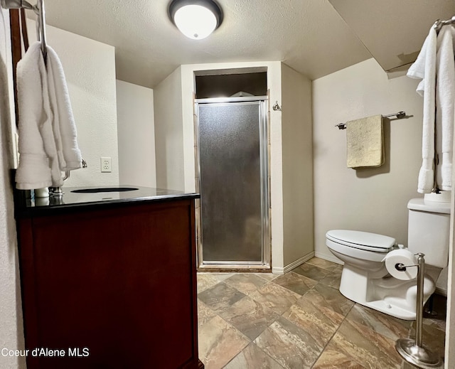 124 King St, Wallace, ID 83873 - full bath featuring toilet, vanity, a stall shower, baseboards, and a textured ceiling