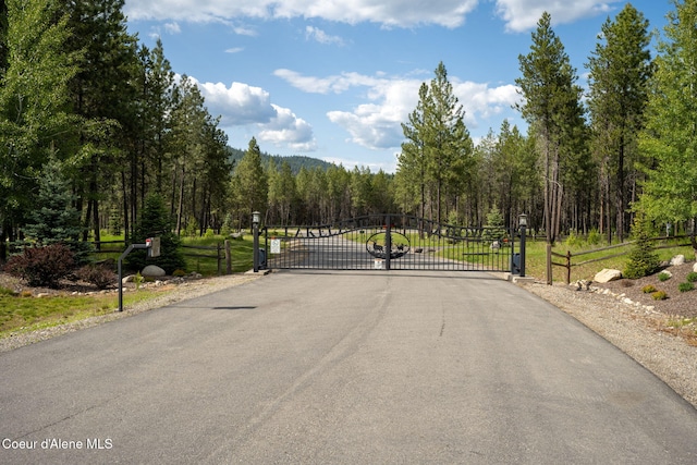 6036 W Sparrowhawk Dr, Rathdrum, ID 83858 - view of asphalt road with a gate and a forest view