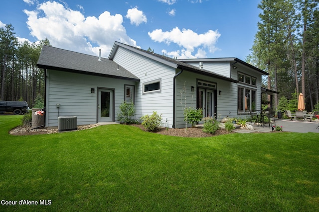 6036 W Sparrowhawk Dr, Rathdrum, ID 83858 - rear view of house featuring a patio, a yard, and a shingled roof