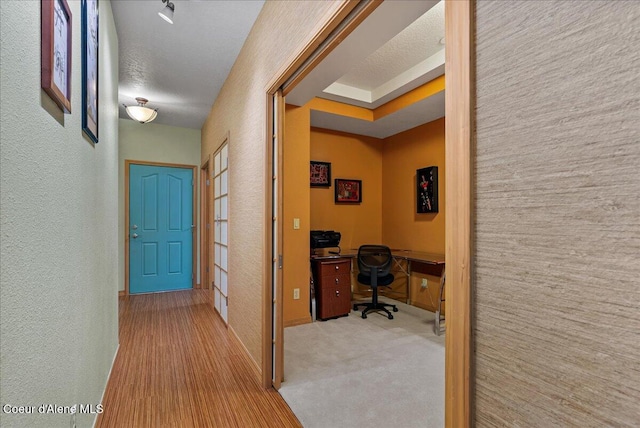 1010 E Mullan Ave Unit 202, Coeur Dalene, ID 83814 - hallway with an office area, a textured wall, baseboards, and carpet
