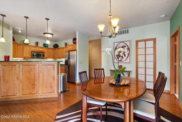 1010 E Mullan Ave Unit 202, Coeur Dalene, ID 83814 - dining room featuring wood finished floors, a chandelier, and baseboards