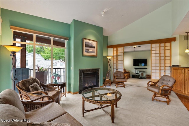 1010 E Mullan Ave Unit 202, Coeur Dalene, ID 83814 - living area featuring a glass covered fireplace, vaulted ceiling, carpet floors, baseboards, and ceiling fan